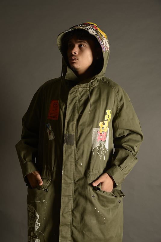 Olive field jacket, full length, hood up.
